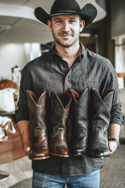 Will Roman holding a pair of Chisos boots